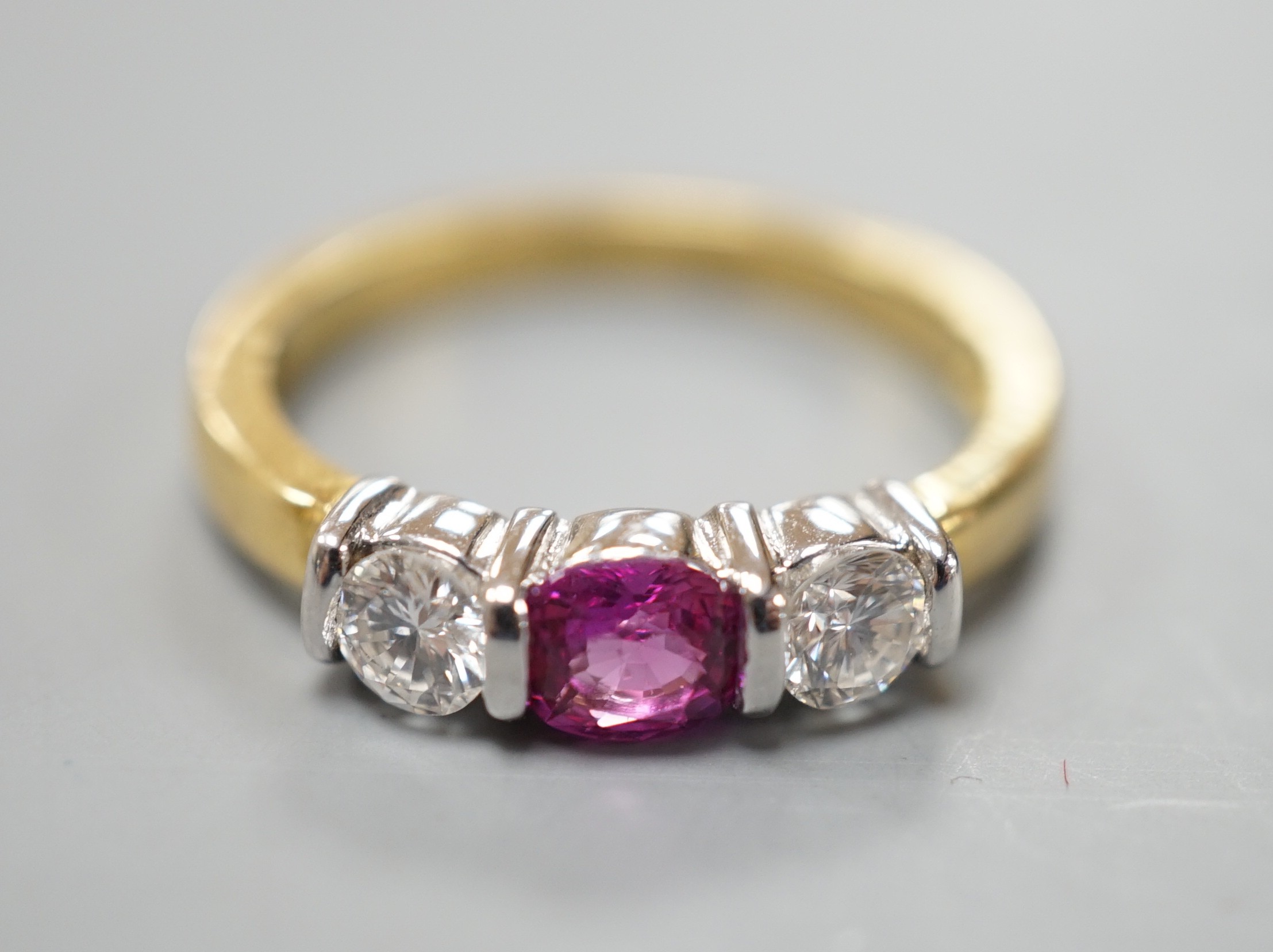 A modern 18ct white gold pink sapphire and diamond set three stone ring, size M, gross weight 4 grams